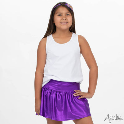 Young girl wearing a white tank top and purple skirt with a white background
